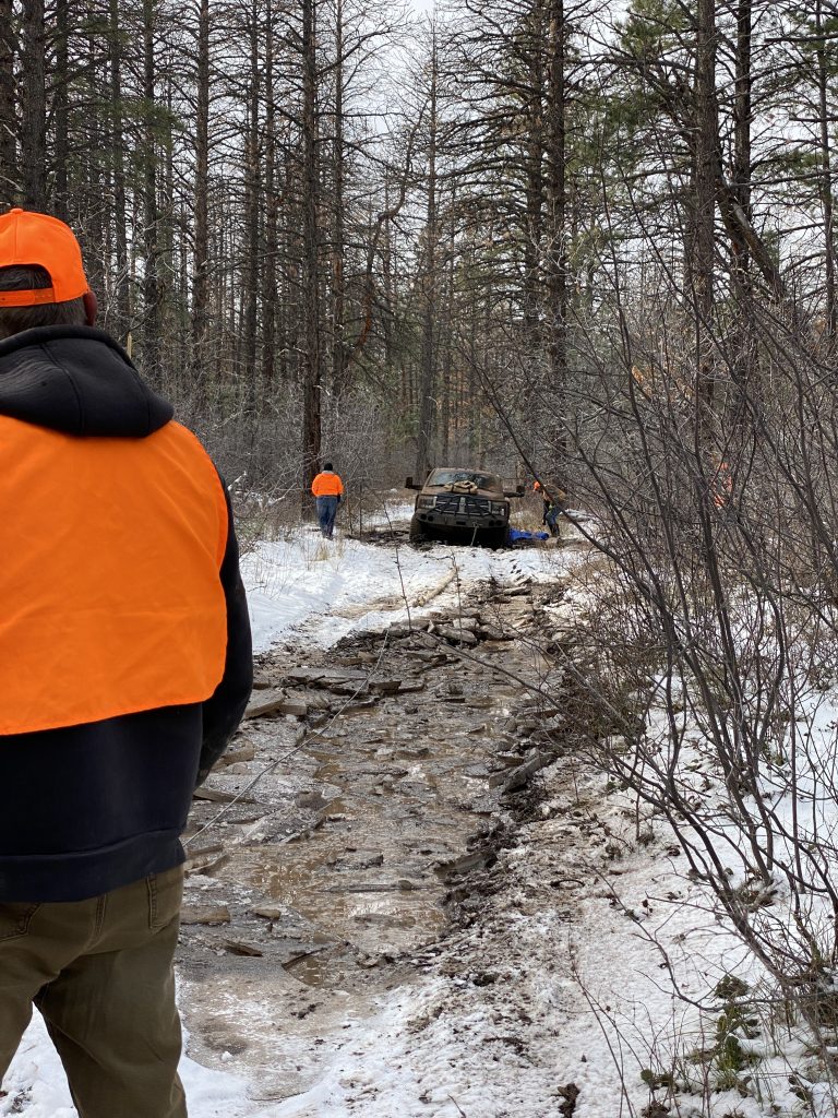 Hunters helping a truck in the mud.